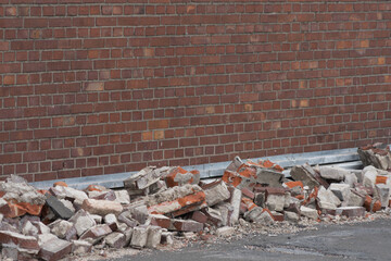 Background of old red exposed brickwork, with brick garbage in front of the wall