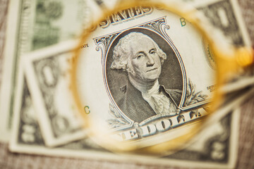 Close-up portrait of George Washington with dollar bill through magnifying glass loupe