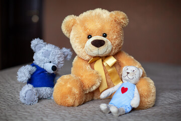 Teddy bears on the bed in the children's room. Baby waiting concept, cute fluffy toys. Horizontal format. Atmospheric mood photo. Front view, close-up. Soft selective focus