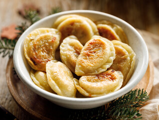 Close-up view of fried dumplings with cheese filling in a ceramic bowl