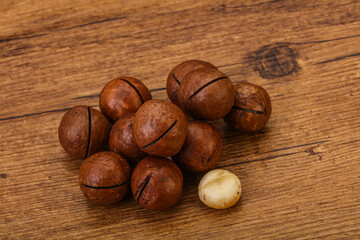 Brown macadamia nut heap over background
