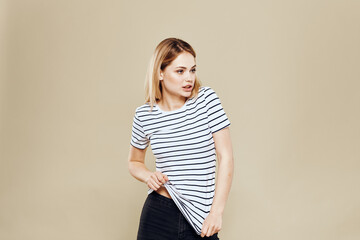 Obraz premium Cheerful woman striped t-shirt studio beige background lifestyle emotions