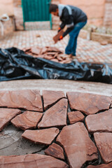 Master bricklayer professionally lays stone tiles on the concrete floor of the terrace - chaotic natural decor