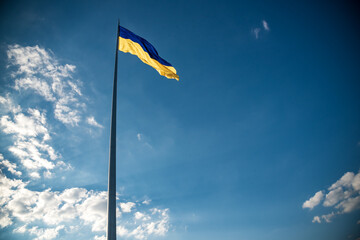 Ukrainian flag on top of hill. clear blue sky with clouds