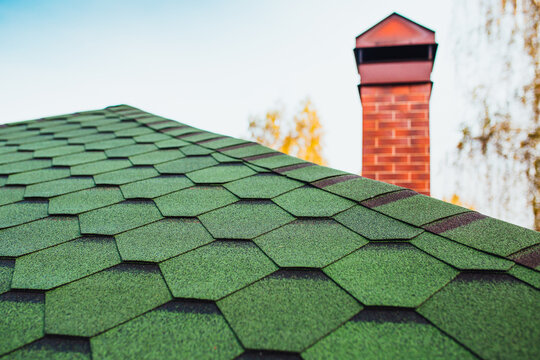 Roofing Made Of Soft Bitumen Tiles Of Green Color On The Hipped Roof Of A Country House