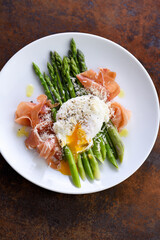 Eggs Benedict with parmesan, green asparagus and Parma ham.