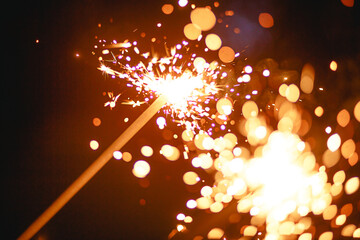 Sparks and sparklers in the dark. Festive fire texture, background for new year and Christmas.