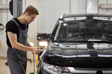 hard-working auto mechanic worker polishing car at automobile repair service, renew service station...