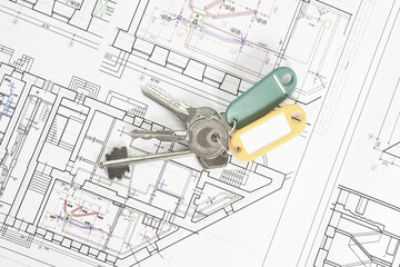 architectural drawings on a white sheet with keys to the house, the concept of construction and design of real estate