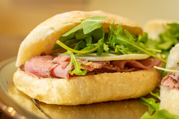 Prosciutto Italian sandwich with arugula and provolone cheese - close up