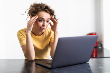 Frustrated sad woman feeling tired worried about problem sitting on sofa with laptop, stressed depressed girl troubled with reading bad news online, email notification about debt or negative message