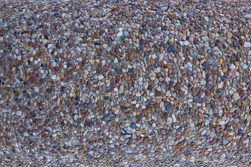 Fototapeta premium texture of stones in a light-colored concrete fence, crushed stone
