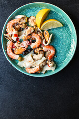 seafood salad or appetizer shrimp, mussels, squid and other ingredients top view copy space for text food background rustic pescetarian diet