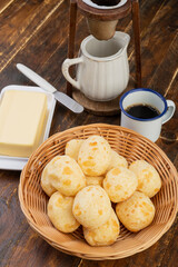Typical brazilian cheese bun in a basket with coffee over wooden table