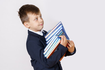 The student holds books in his hands and looks away. Isolated on white background.