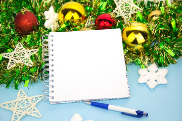 Notepad for notes with a pen and Christmas decorations. New year's blue background. Space for text. Background of the new year. Christmas. Noel. Clean open Notepad, Christmas gifts