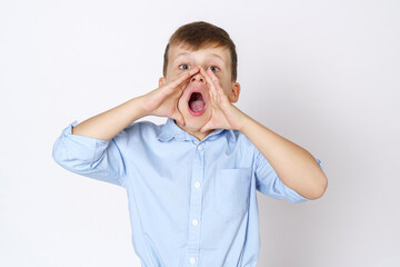 The boy expresses emotions, shouts, pressing his hands to his mouth. Isolated over white background.