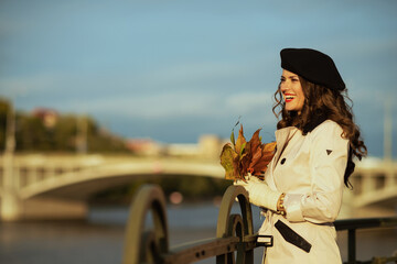 smiling 40 years old woman in beige trench coat and beret