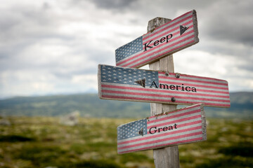 keep america great text on signpost with the american national flag.