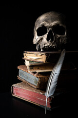 Human skull resting on ancient books. Black background with space for text