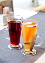 Mulled wine in tall glasses in a cafe. Warming drink with fruits and spices..