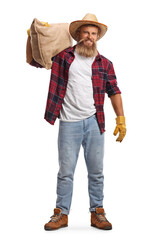 Full length portrait of a young bearded farmer carrying a sack on his shoulder