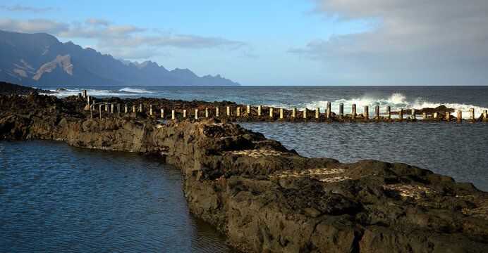 Natural pools in foreground and northwest coast of Gran Canaria, Agaete, Spain