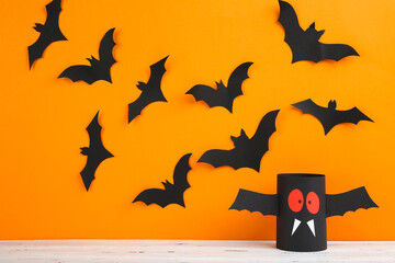 Halloween paper bats and ghost on orange background