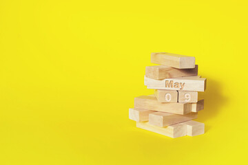 May 9th. Day 9 of month, Calendar date. Wooden blocks folded into the tower with month and day on...