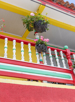 Balconies and windows in red, blue, green, yellow, with gardens and flowers, in the coffee region in Colombia.