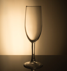 Champagne glass on a light brown background. Concept of holiday backgrounds.