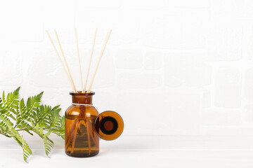 Air refresher bottle mock up, reed diffuser on a white background with fern leaf. Home fragrance...