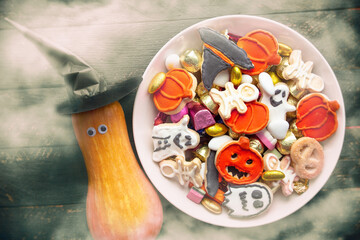 pumpkin in a black witch hat, a bowl of chocolates and sweets, Halloween Jack o Lantern cookies - Trick or Treat Halloween card background