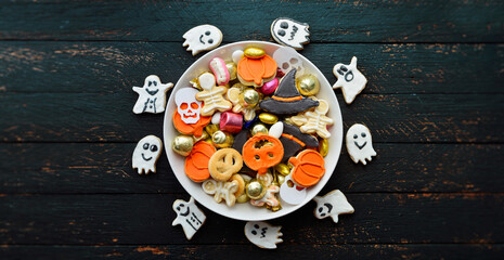 pumpkin in a black witch hat, a bowl of chocolates and sweets, Halloween Jack o Lantern cookies - Trick or Treat Halloween card background