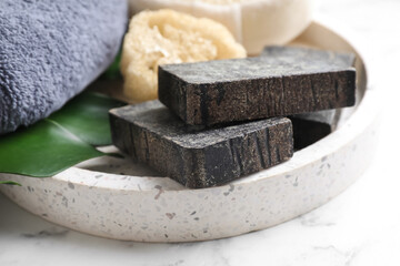 Natural tar soap on white marble table, closeup