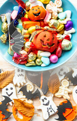 Fototapeta na wymiar candy bowl of chocolates and sweets, Halloween Jack o Lantern cookies - Trick or Treat Halloween card background