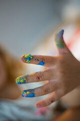 Colorful painted child hand with many finger colors