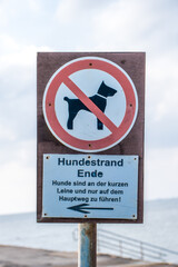 The sign to walk dogs is prohibited against the background of a cloudy sky.