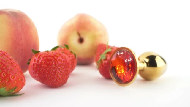 close-up. peach, strawberry and butt plug isolated on white background.