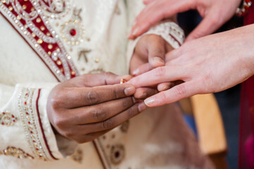 Indian groom putting ring on a brides hand