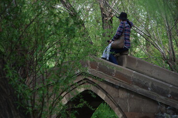 Obraz na płótnie Canvas A lady waiting over a stone bridge