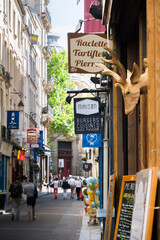 Street of Paris with restaurants signs, tourists walking 