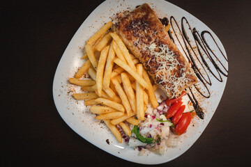 roast meat with cheese and salad on a plate and salad on a plate
