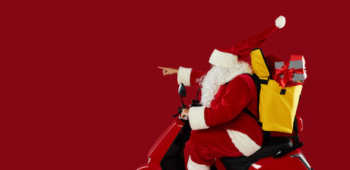 Santa claus courier in a protective mask and gloves is quickly carrying a gift boxes  on a red...
