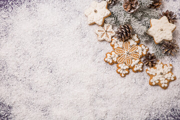 Christmas background, spruce branch with cones and gingerbread cookies on a white snowy background. View from above. Idea, holiday concept.