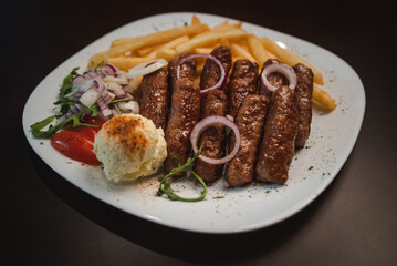 peceni rostilj sa pomfitom i salatom na tanjiru, srpsko jelo 