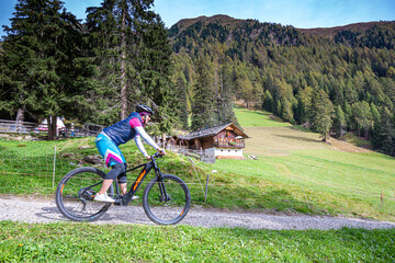 Obraz premium Italy, South Tyrol, Pustertal, Bruneck, Portrait of woman riding an E-Mountain bike