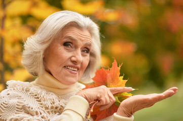 Happy senior beautiful woman in autumn park