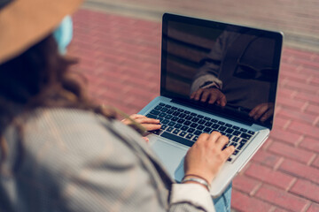Perfil de una mujer que usa su computadora al aire libre.