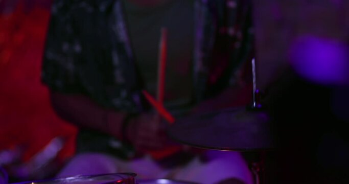 Close-up of male drummer playing drums in music studio